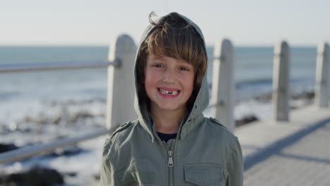 Retrato-Feliz-Niño-Sonriendo-Alegre-Disfrutando-De-Las-Vacaciones-En-La-Hermosa-Y-Soleada-Playa-Usando-Una-Cálida-Chaqueta-En-Cámara-Lenta