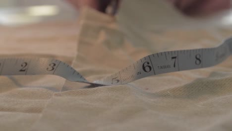 seamstress cuts measured cloth