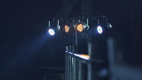 bright lights from the projector shining from the scene on the blurred background. projector lens lightning at disco on a special stand intdoors.