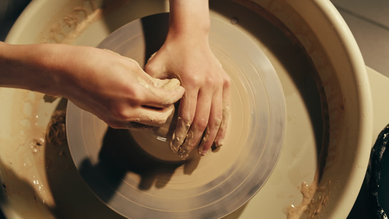 Donna che modella l'argilla su una ruota di ceramica