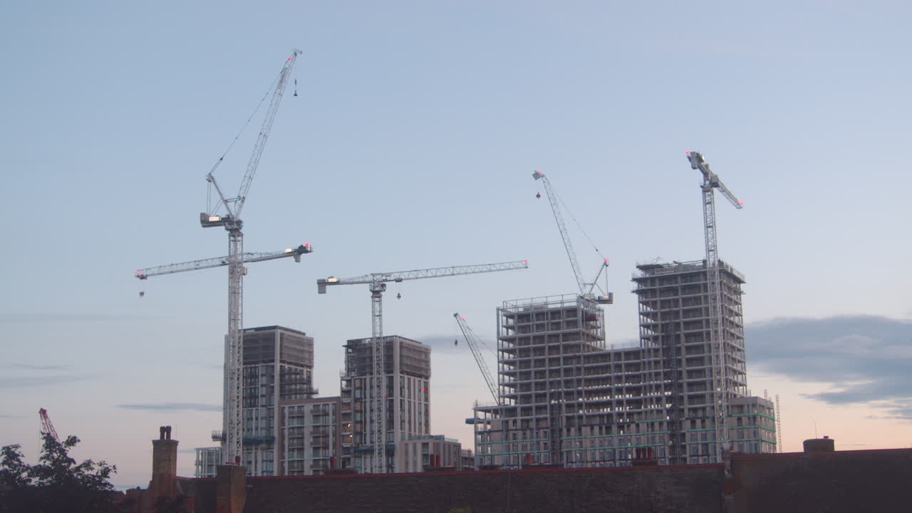 el horizonte de la ciudad moderna de londres y el paisaje urbano en construcción con grúas y trabajos de construcción en la hermosa puesta de sol y la noche