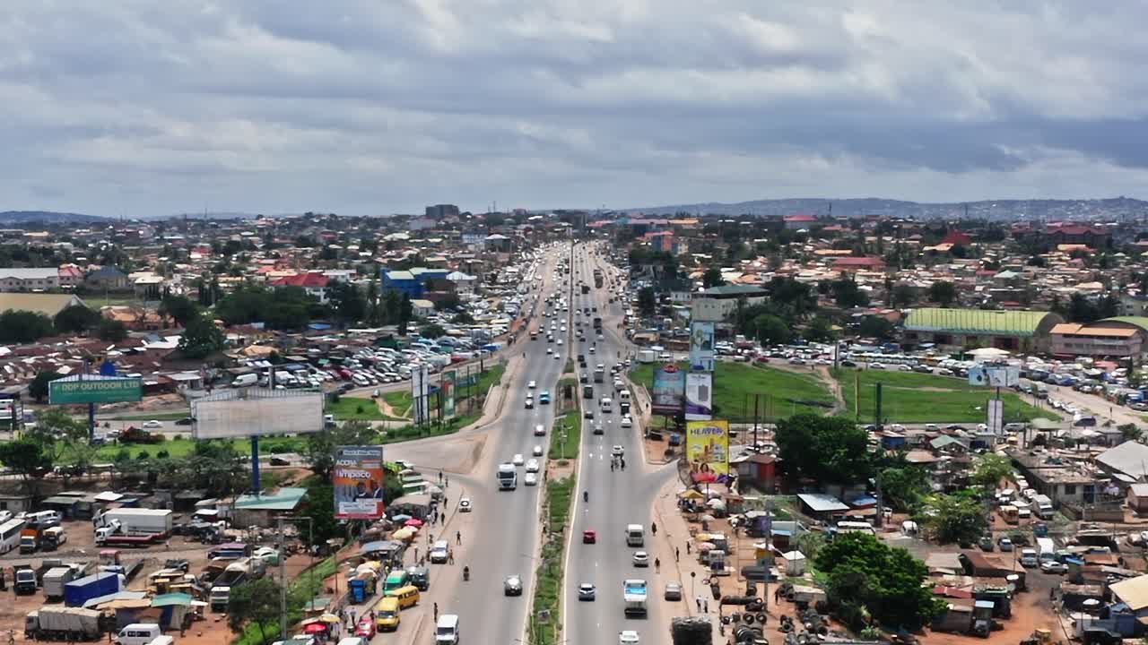Trafik på en livlig väg i Accra, Ghana under molnig himmel