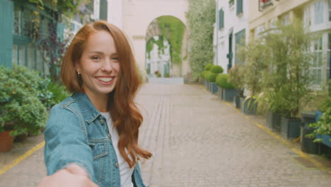 point of view shot of young woman leading man through city street by the hand