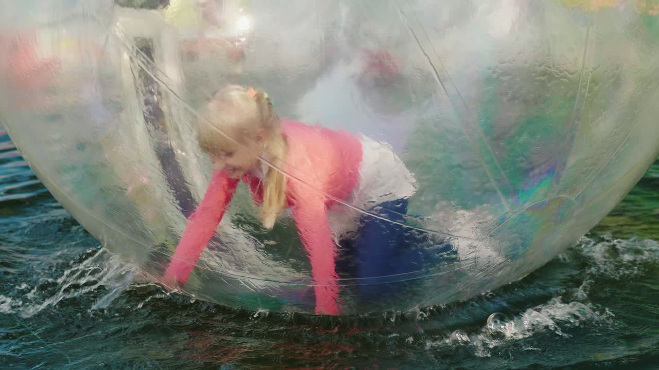 es divertido correr a cuatro patas dentro de una pelota transparente que flota en la piscina actividades acuáticas 4k s