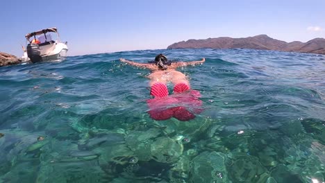 niña buceando, buceando bajo el agua, buceando en el mar mediterráneo en busca de peces durante el verano
