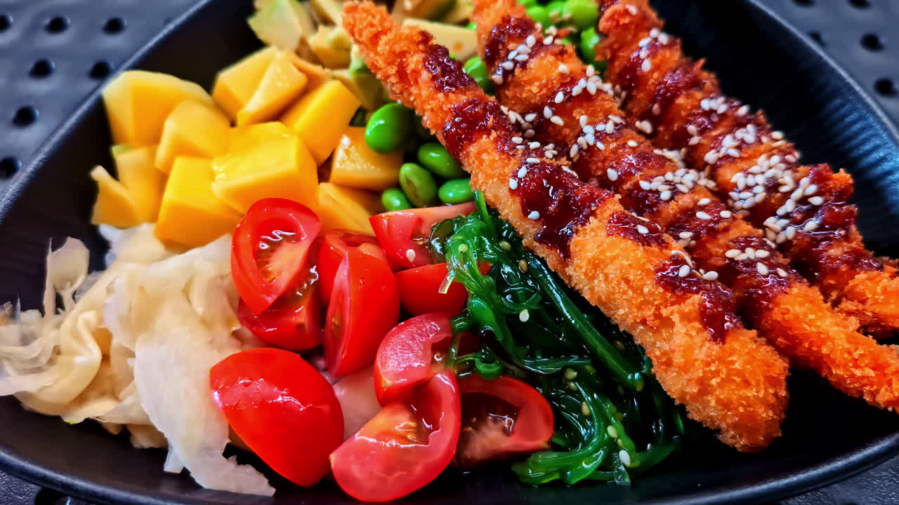 Profile view of fried prawns with ketchup and poke bowl