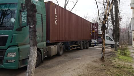 cargo truck downloading maritime container at destination