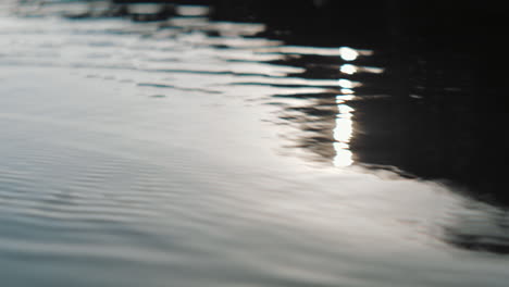 Sun-reflecting-on-the-surface-of-the-water-on-a-lake-at-sunset-in-golden-hour