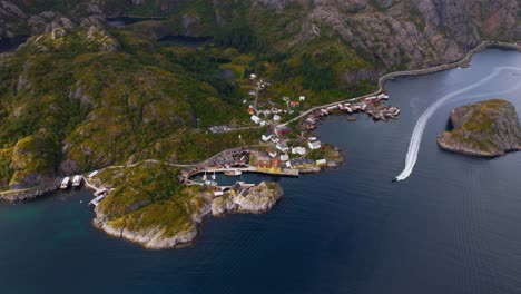 historic village with red and yellow fishermen’s cabins and boats on lofoten shoreline. norway aerial