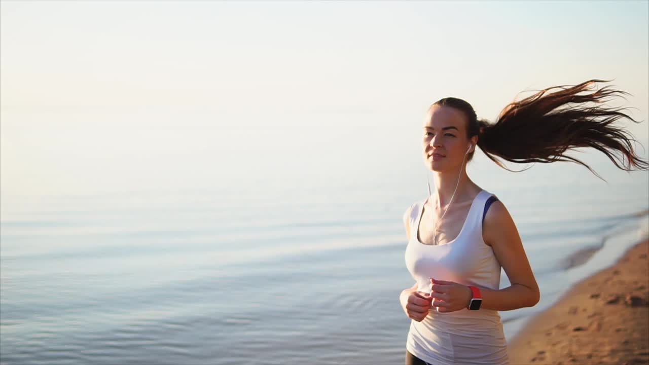 mujer corriendo en la playa al amanecer
