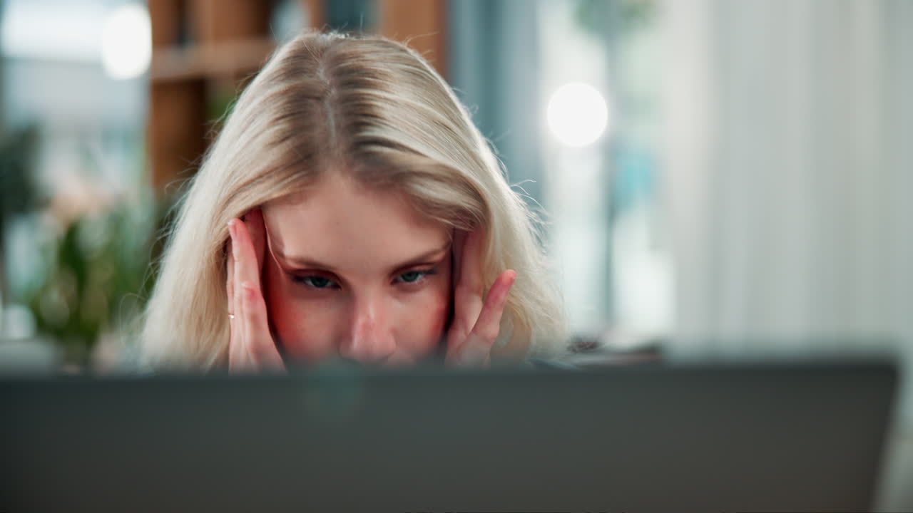 Woman with headache in front of laptop
