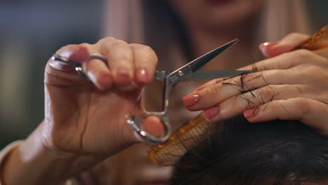 close up of men's hair cutting scissors in a beauty salon. frame. close up of a haircut at a hair saloon. professional barber styling hair of his client