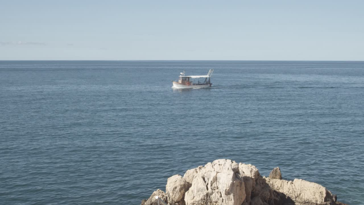 plano general del barco de pesca que regresa a casa después de la captura de peces en el mar adriático durante el día soleado