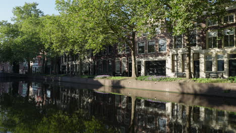 grandes canales con reflejos de árboles en la calle lage gouwe, centro de la ciudad de gouda, países bajos