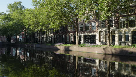 large canals with tree reflections at lage gouwe street, gouda city center, netherlands