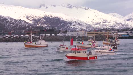 a large fleet of commercial fishing boats sails out to sea of norway in the lofoten islands 2