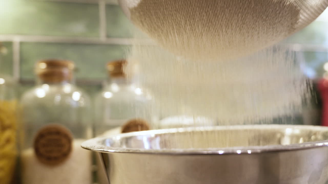 Baking preparation by sifting flour into a kitchen bowl