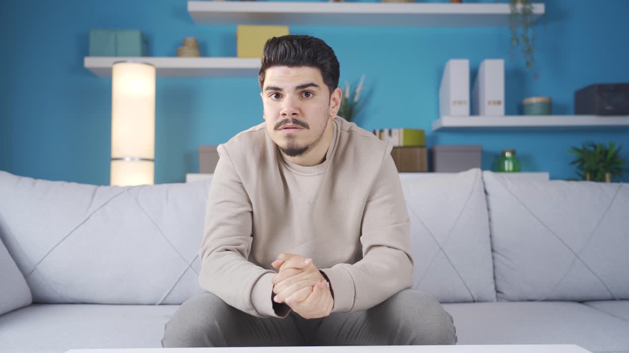 걱정하고 불안하게 주위를 둘러보는 남자는 카메라를 쳐다보고 있습니다.