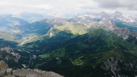 aerial top down shot of idyllic mountain landscape with green valley in italy - tilt down showing dangerous cliffs on mountaintop