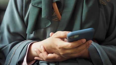 woman using smartphone in an abaya