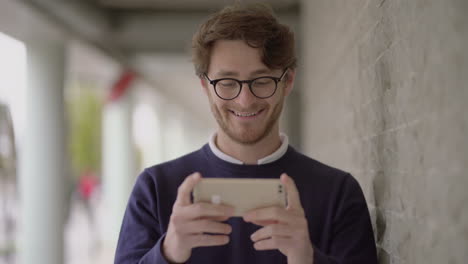 Handsome-happy-man-using-smartphone-outdoor