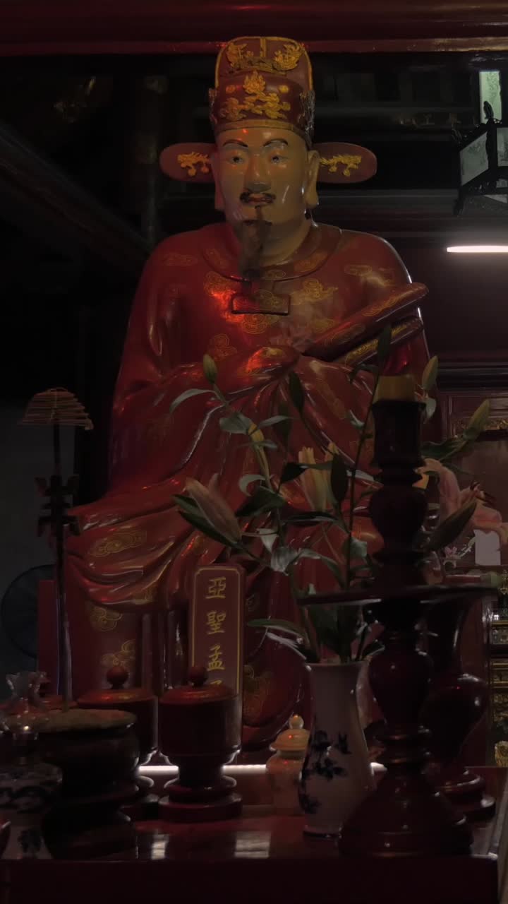 Estátua Ornamentada de Divindade Vermelha e Dourada em um Altar em um Templo Pouco Iluminado