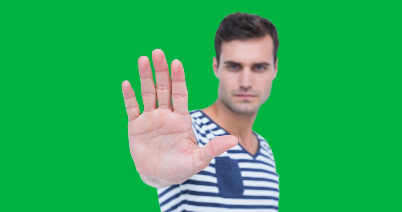 Ritratto di uomo caucasico che fa il segno di stop con la mano su sfondo nero