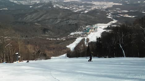 Experimente-La-Emoción-Del-Snowboard-Mientras-Un-Ciclista-Desciende-Hábilmente-Pendientes-Negras,-Realiza-Atrevidos-Saltos-Y-Giros-Cerrados-Contra-Un-Impresionante-Telón-De-Fondo-De-Montaña-En-Este-Emocionante-Video