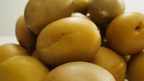 aceitunas verdes redondas en vinagre de grecia como fondo, vista de arriba. imágenes de alta calidad en 4k