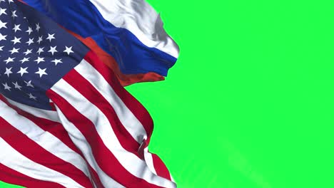 флаги сша и россии, развевающиеся на ветру, изолированы на зеленом фоне.