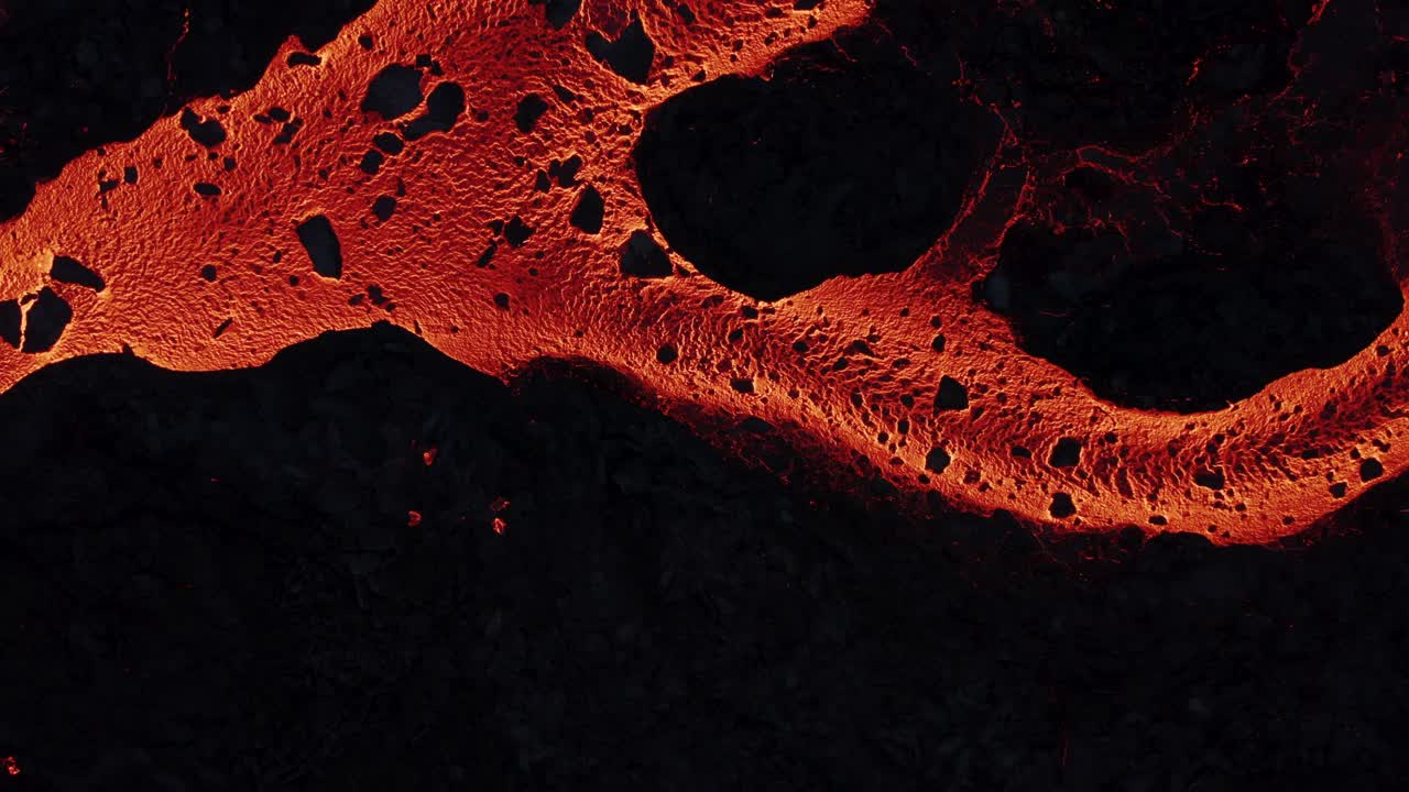 Molten river of glowing lava at night in Fagradalsfjall volcano effusive eruption, top down