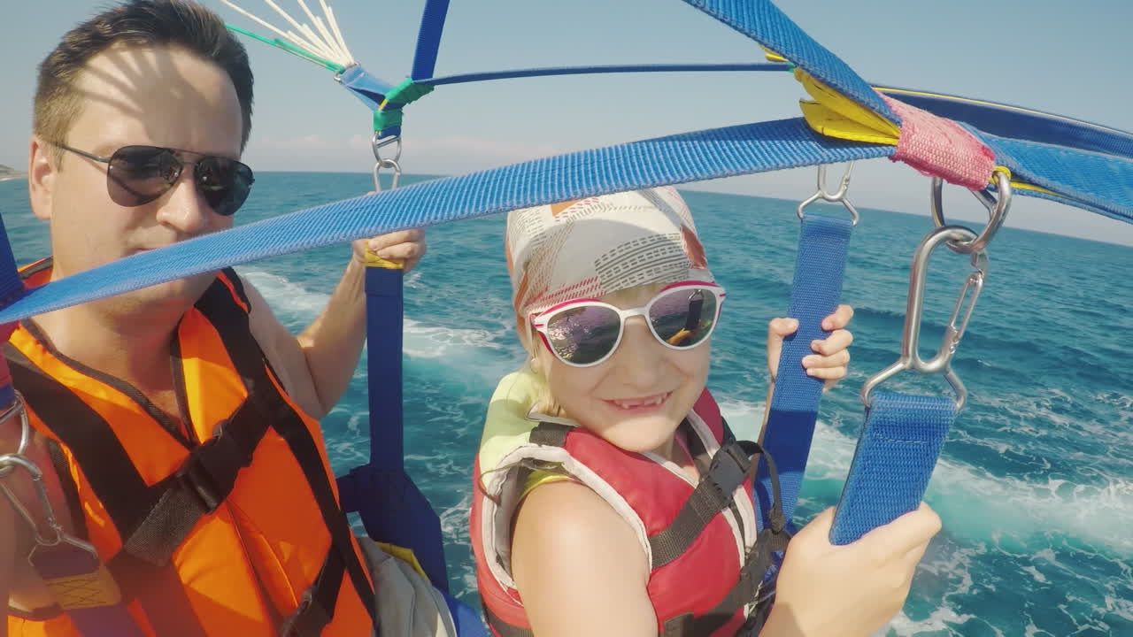 padre e hija vuelan en parasailing un padre se toma una selfie con una chica unas vacaciones activas wi