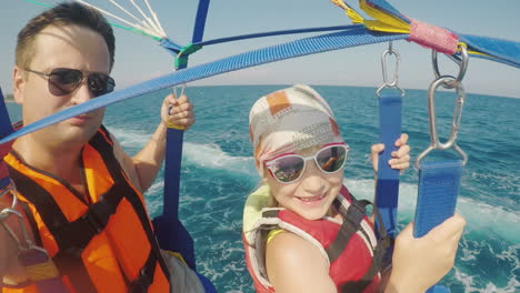 dad and daughter are flying on parasailing a father takes a selfie with a girl an active vacation wi