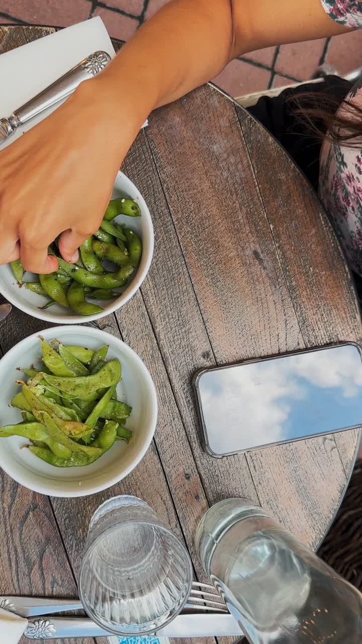 disfrutando del almuerzo de edamame en un café al aire libre