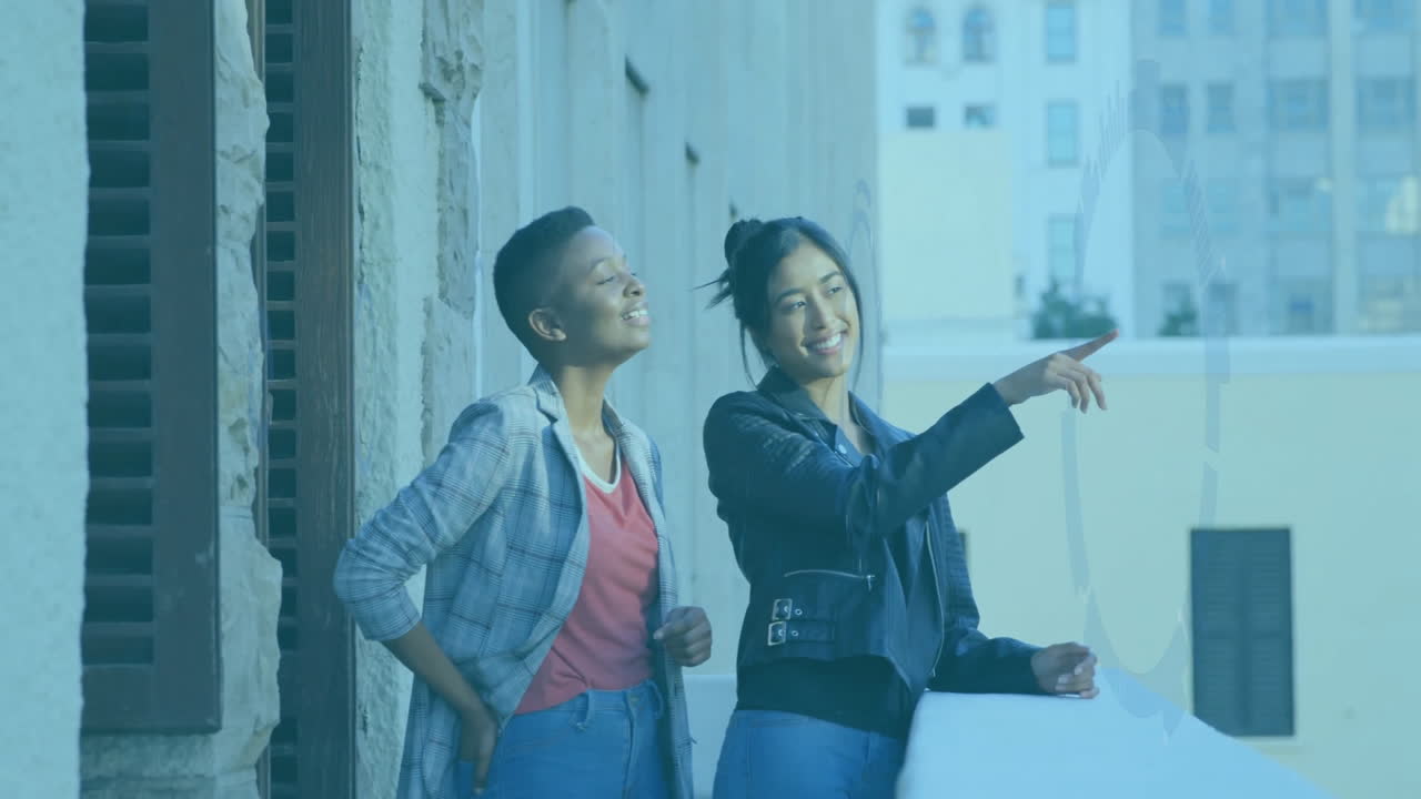 Pointing at animation, two people smiling while standing on balcony