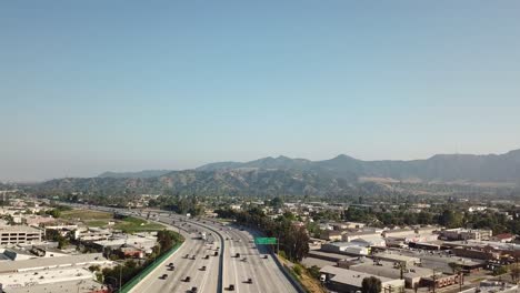 aerial shot of the 5 highway in burbank, los angeles, california with griffith park in the background during sunset