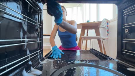 woman cleaning a dirty oven