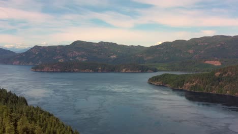 Vista-Del-Río-Campbell:-El-Dron-Roza-Los-árboles,-Revela-El-Océano-Iluminado-Por-El-Sol-En-La-Isla-De-Vancouver