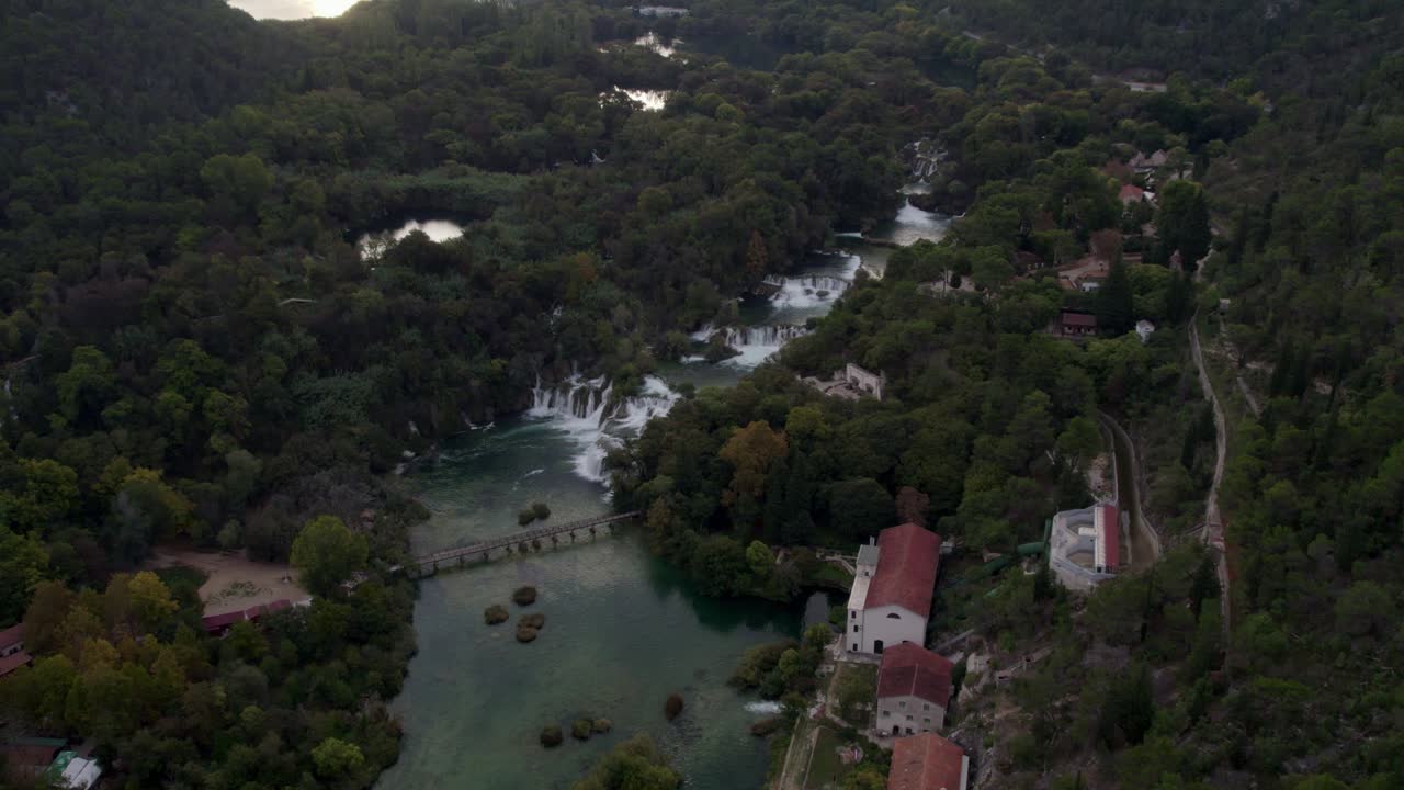 Vista aerea di alberi rigogliosi e della cascata del Krka, circondati da un fiume sereno, Croazia.