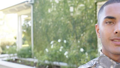 portrait of happy biracial male soldier in garden