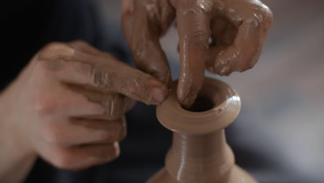 hands shaping a clay vase