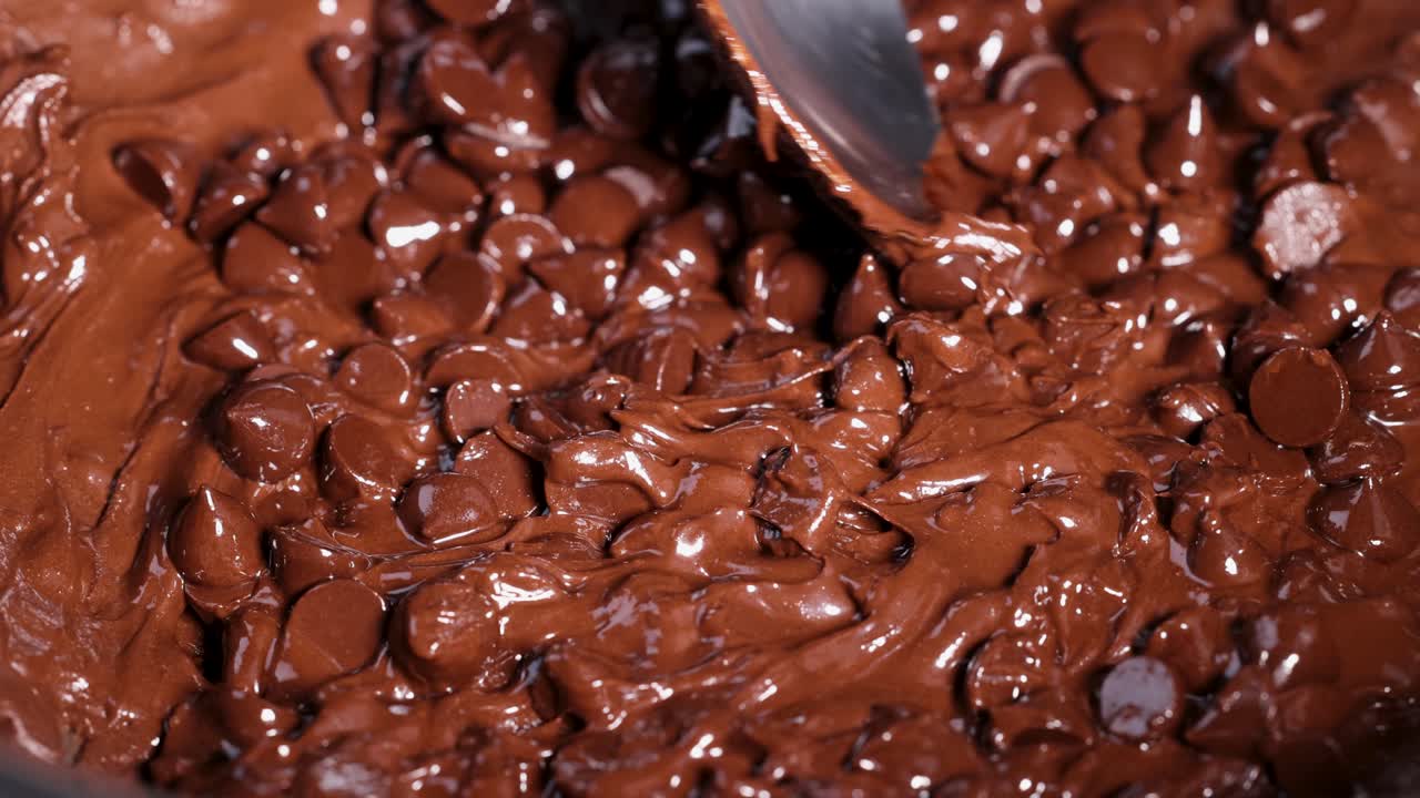 крупный план ложки, плавно перемешивающей расплавленные шоколадные чипсы