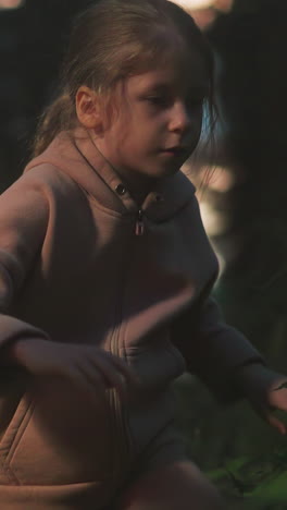 little children siblings walk through night wood together. scared boy and girl seek way to home in wild park in evening. small kids lost at forest area