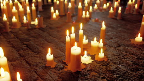 many candles lit on a brick surface