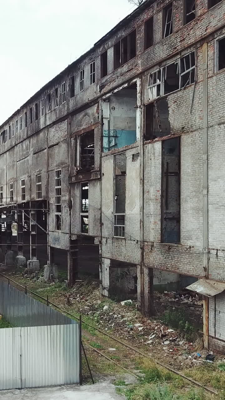 Take-off of the drone at an abandoned factory. Old abandoned factory building. Aerial View. Vertical video