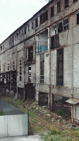 take-off of the drone at an abandoned factory. old abandoned factory building. aerial view. vertical video