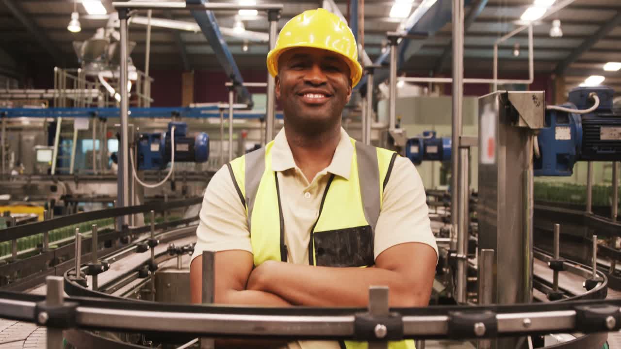 Portrait of worker standing with arms crossed near production line