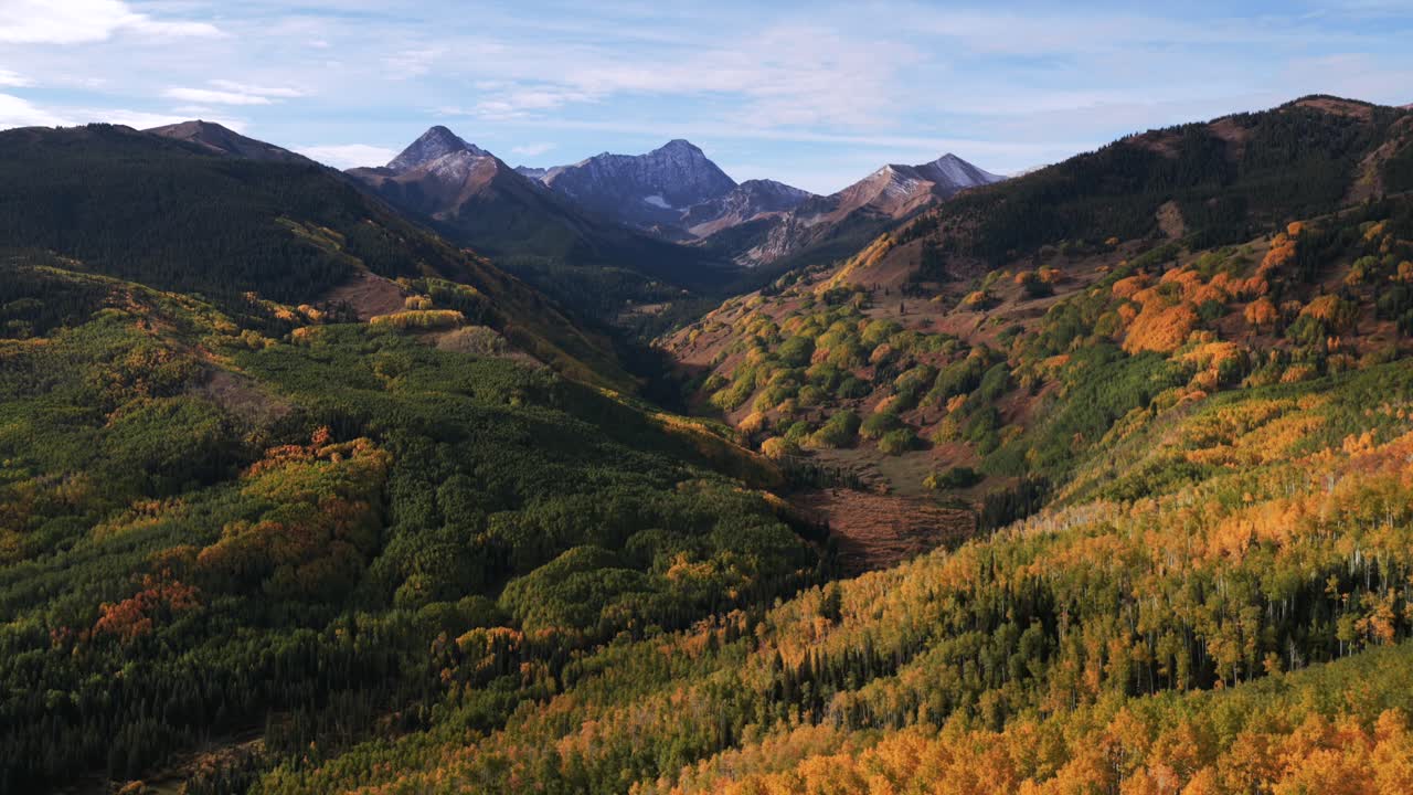 Aspen Snowmass, Kolorado – lotnicze ujęcie z drona, szczyt Capitol Peak (4267 m n.p.m.), dzika przyroda, słoneczny poranek, jesień, złocistożółty zagajnik osikowy, White River Forest, Góry Skaliste, pasmo Elk Range, błękitne niebo, krajobraz, okrąg po lewej stronie