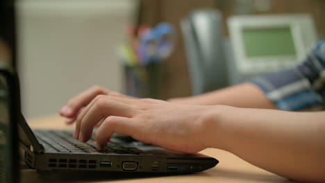 toma en cámara lenta de un hombre escribiendo en su computadora portátil y cerrándola