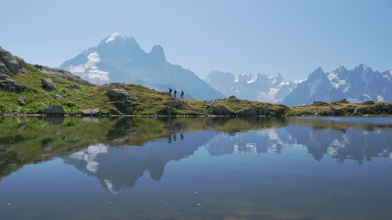 gente caminando por el lac blanc con reflejos de las montañas, en el valle de chamonix, en francia en un día soleado